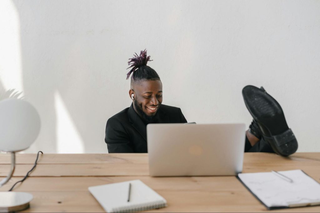 Man sitting on desk with legs top up