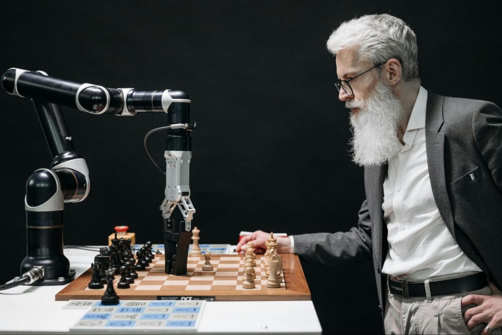 Old man playing chess with robotic hand